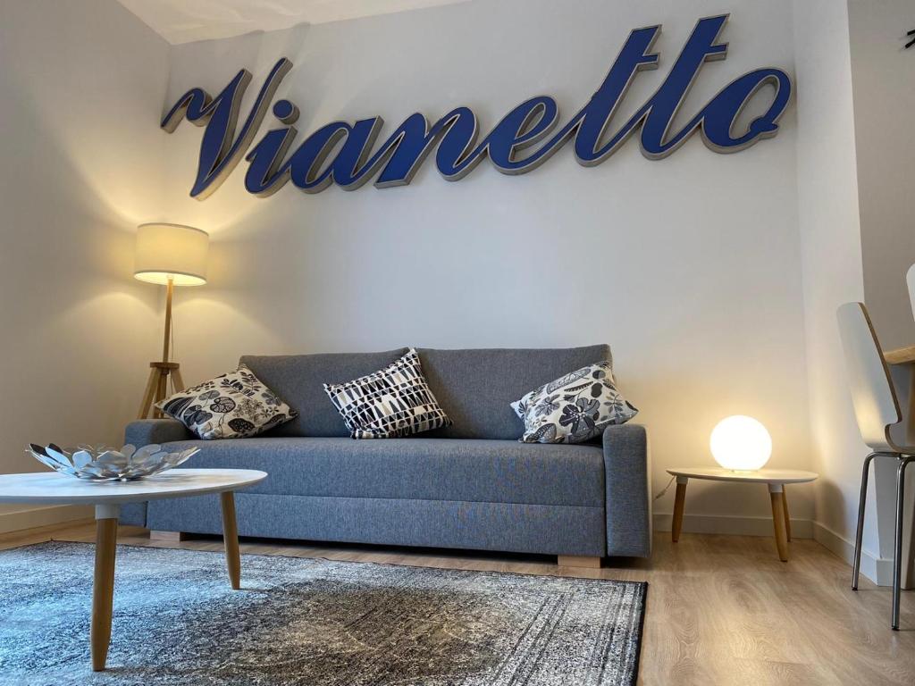 - un salon avec un canapé bleu et un panneau dans l'établissement Vianetto Home, à Monzón