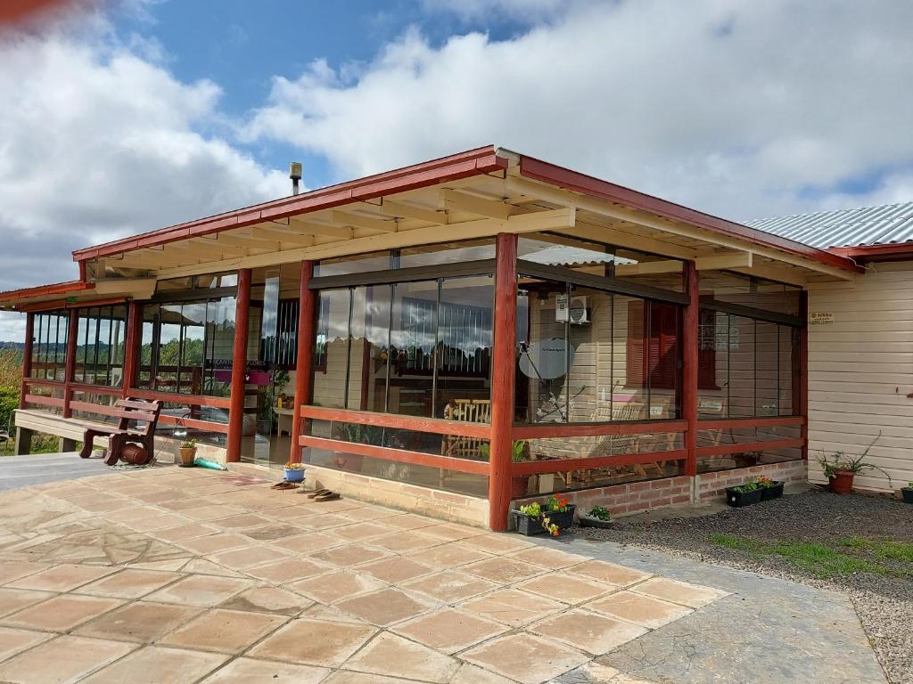 - un bâtiment doté de baies vitrées et d'une terrasse dans l'établissement Pousada Rural Colina do Sol, à Cambará
