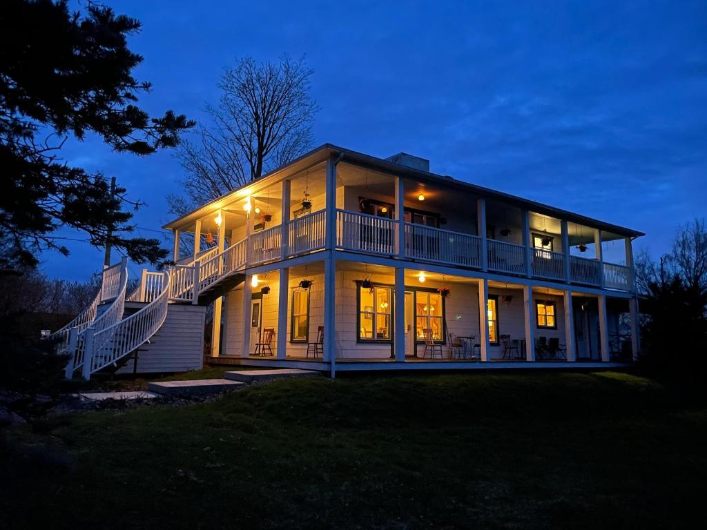 a large house with its lights on at night at Au Coeur des Jardins in Compton