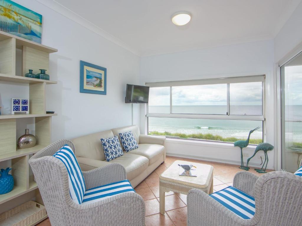 a living room with a couch and chairs and a window at Avalon 1 in Yamba