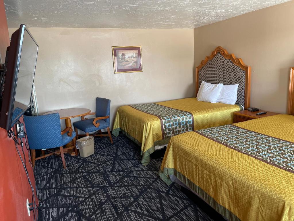 a hotel room with two beds and a flat screen tv at Riverton Inn & Suites Riverton in Riverton