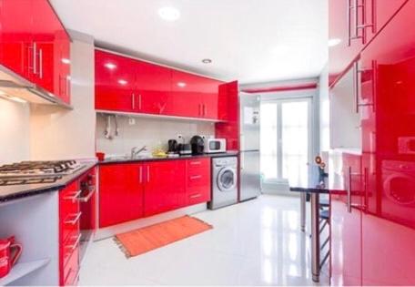 - une cuisine rouge avec des placards rouges et un lave-linge dans l'établissement T3 Alex,moderno iluminado e amplo,excelente local, à Portimão