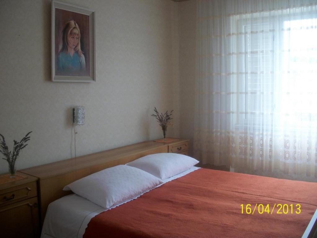 a bedroom with a bed and a picture on the wall at Apartment in Banjol with sea view, terrace, air conditioning, Wi-Fi (3803-1) in Banjol
