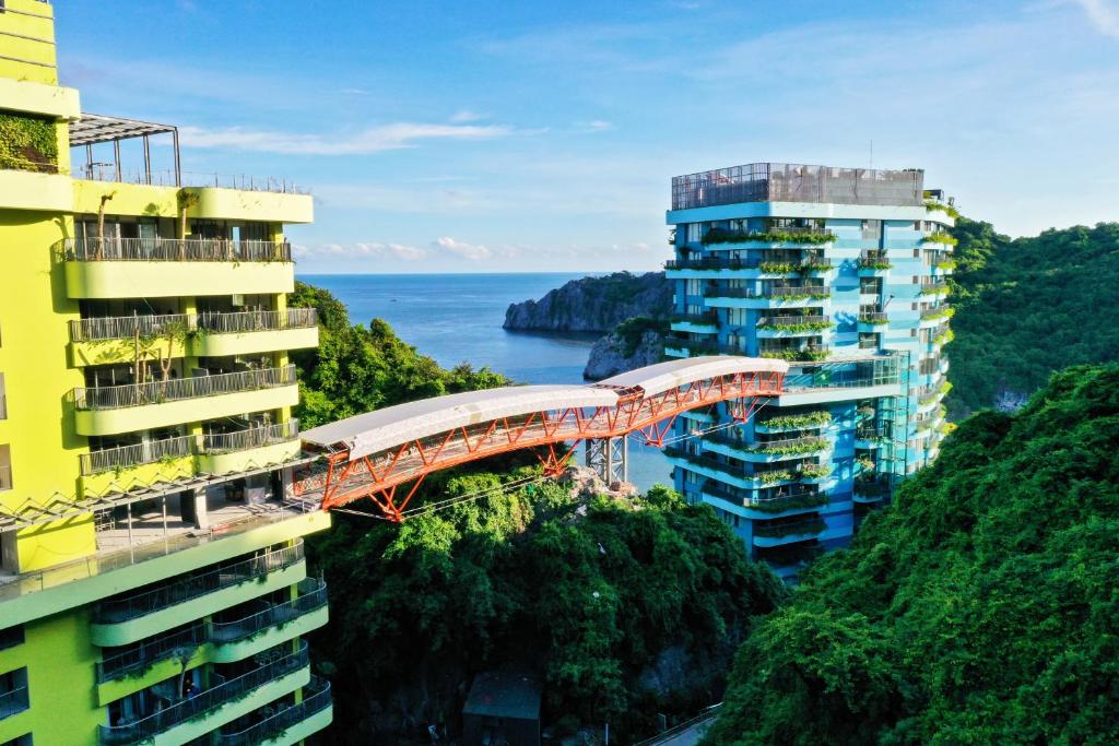 un train sur un pont entre deux bâtiments dans l'établissement Flamingos Cat Ba Resort luxury, à Hai Phong