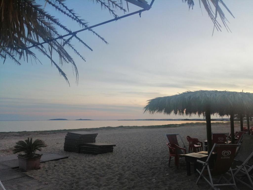 una spiaggia con sedie, tavoli e ombrellone di Casa Contadina a Oristano
