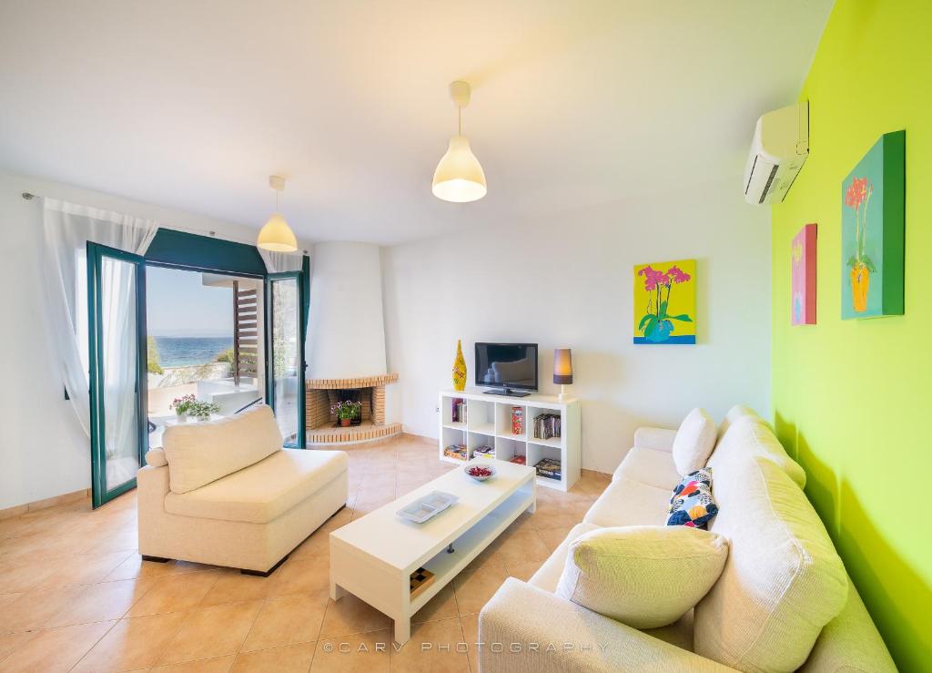 un soggiorno con divano e tavolo di FLUO Seaside Apartment a Vathí