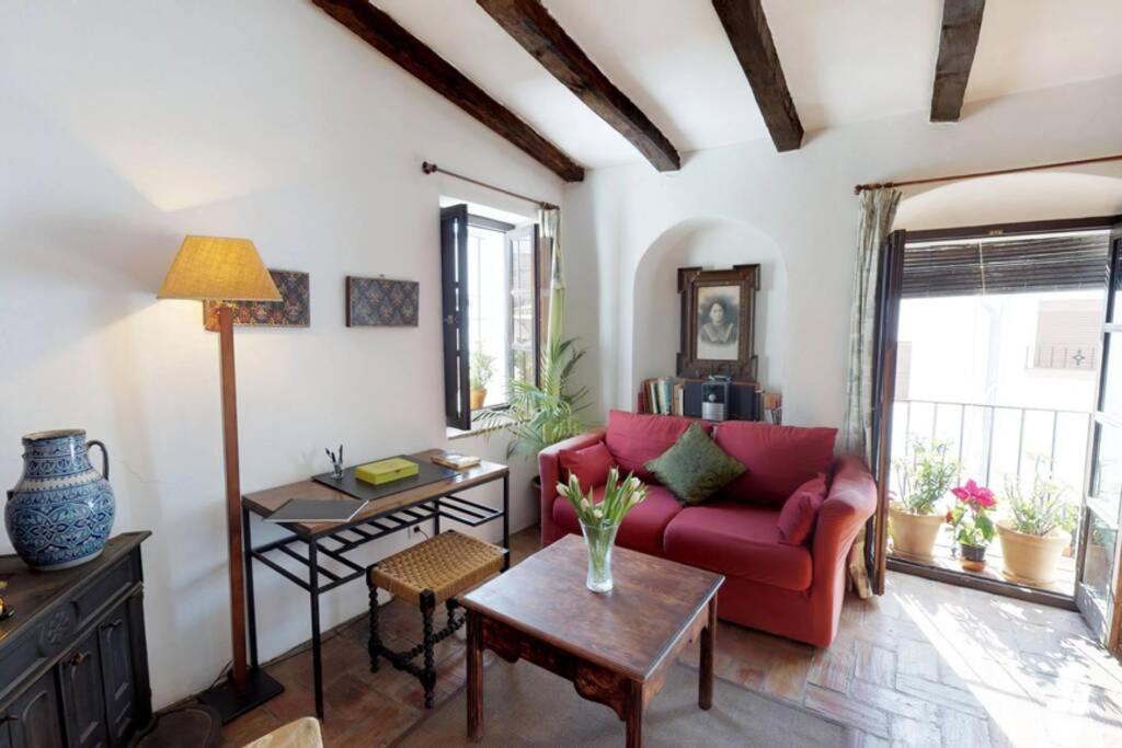 sala de estar con sofá rojo y mesa en El estudio - beautiful apartment in historic old town, en Jimena de la Frontera