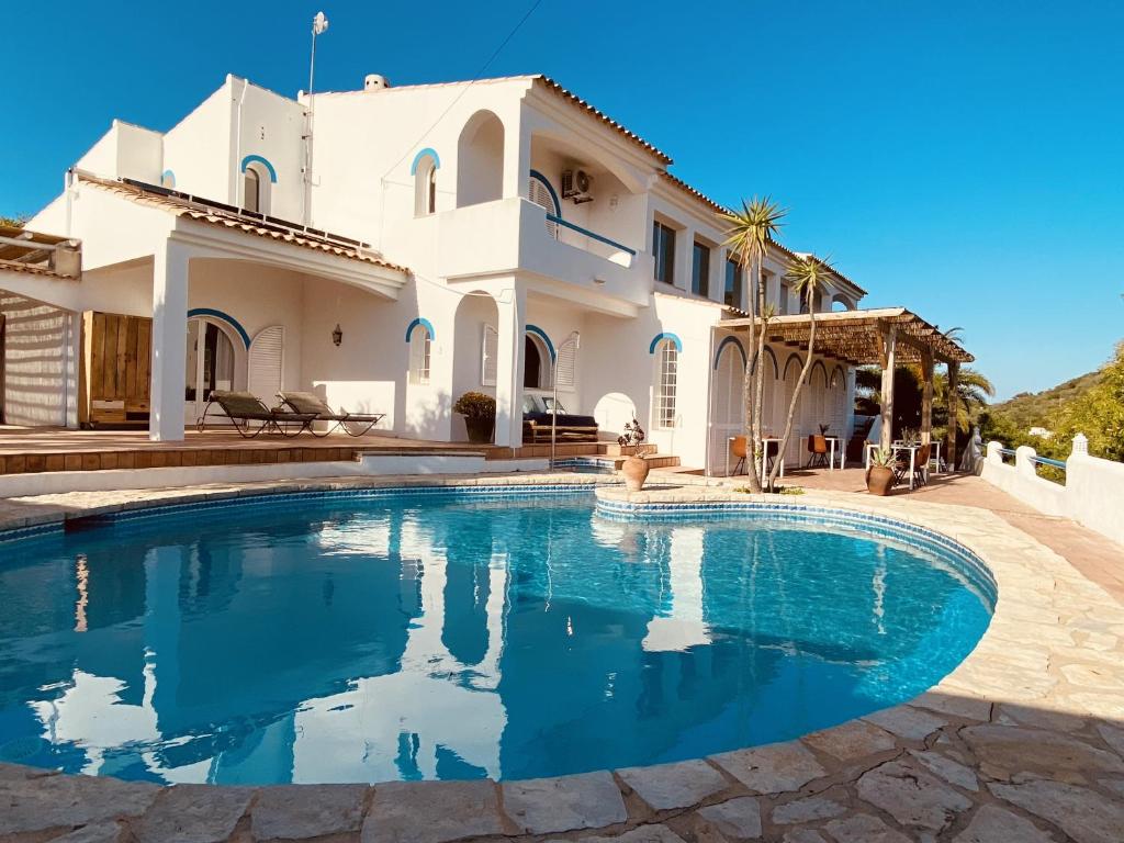 uma grande piscina em frente a uma casa em B&B Casa do Cerro em Moncarapacho