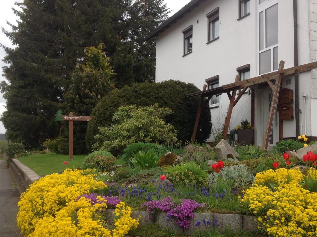 a garden in front of a house with flowers at Ferienwohnung Pasek in Mehlmeisel