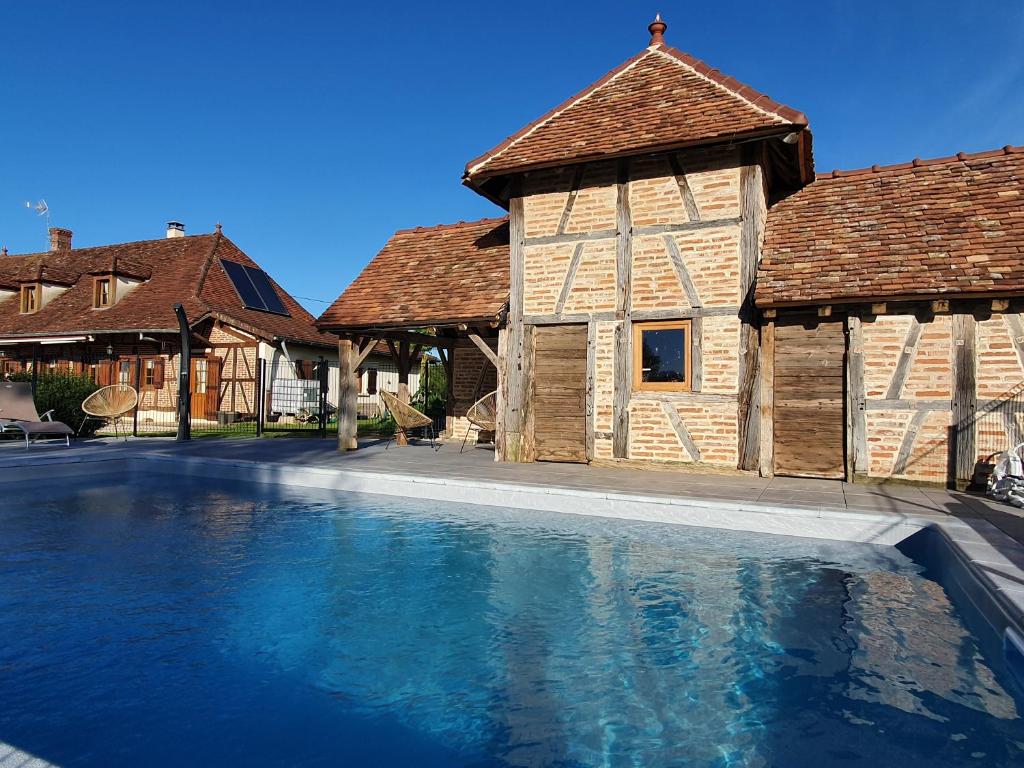 a large swimming pool in front of a building at une Pause à la Campagne in Mervans