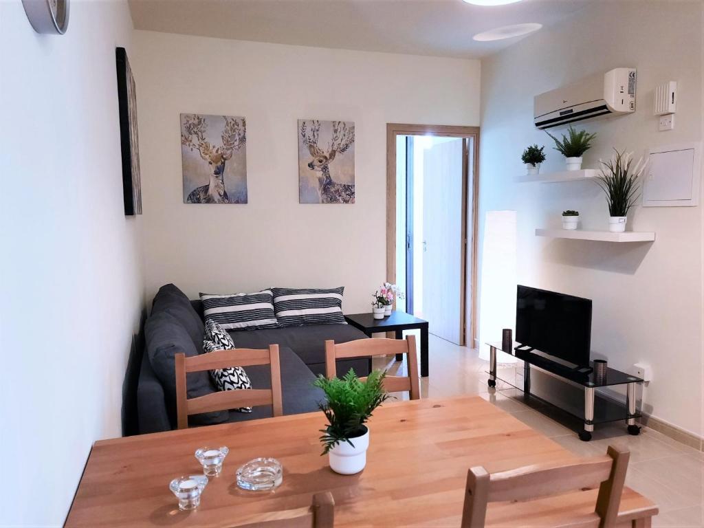 ein Wohnzimmer mit einem Tisch und einem Sofa in der Unterkunft Albert's apartments in Larnaka