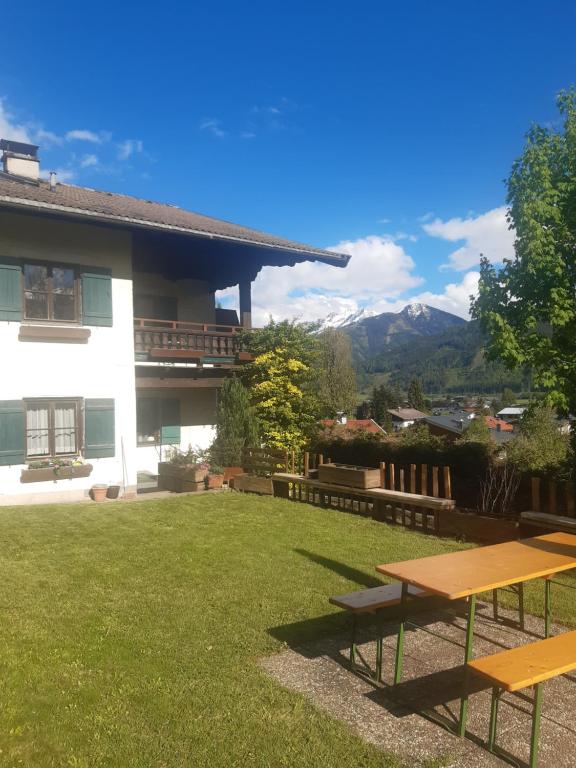 un patio con dos mesas de picnic frente a una casa en Appartement Alpenheim, en Zell am See