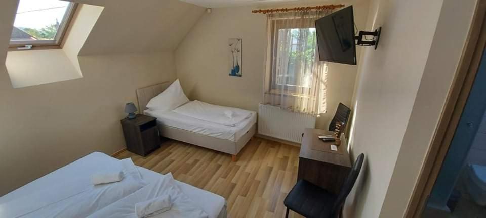 Mały pokój z 2 łóżkami i biurkiem w obiekcie Sörpatika Vendégház w mieście Badacsonytomaj