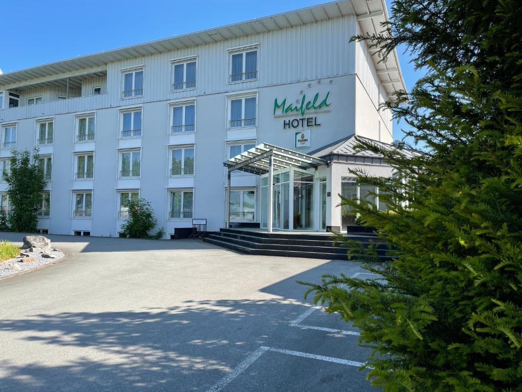 a white hotel with a sign on the front of it at Maifeld Sport- und Tagungshotel in Werl