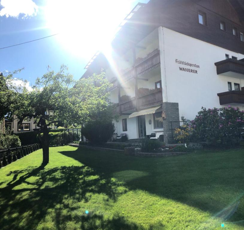 um edifício com um relvado verde em frente em Frühstückspension-Appartementhaus Wasserer em Bad Kleinkirchheim