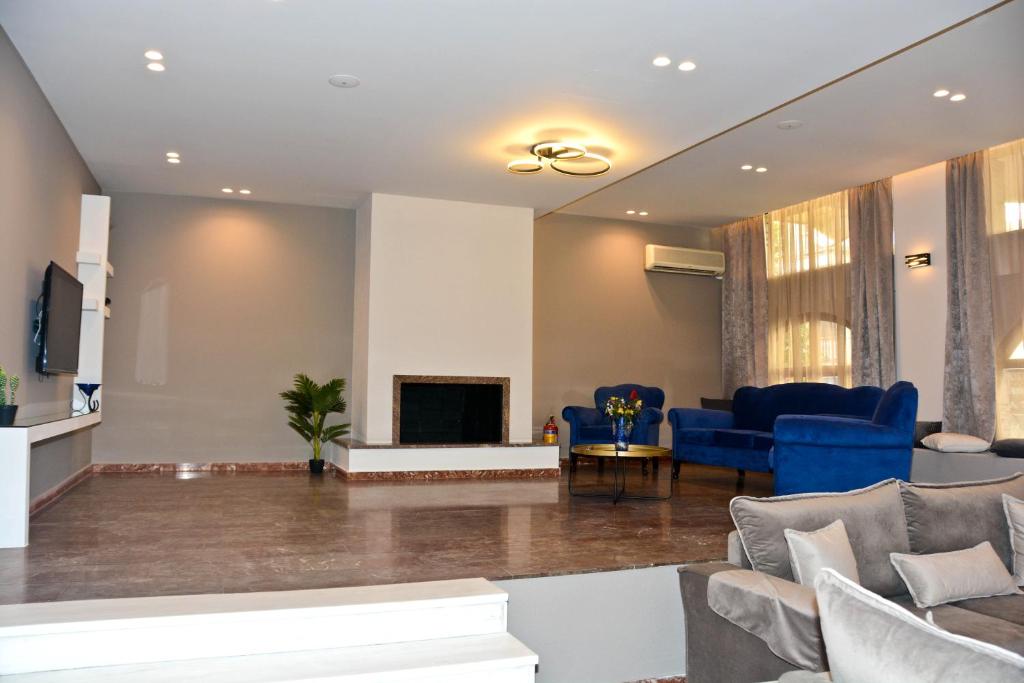 a living room with blue furniture and a fireplace at Hotel Marily in Pyrgos
