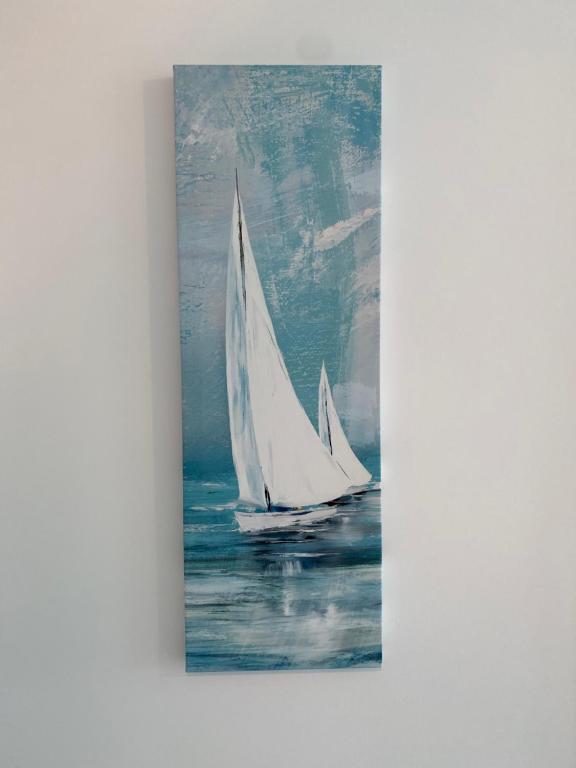a painting of two white sailboats in the water at Ela's Apartment in Mamaia Sat/Năvodari