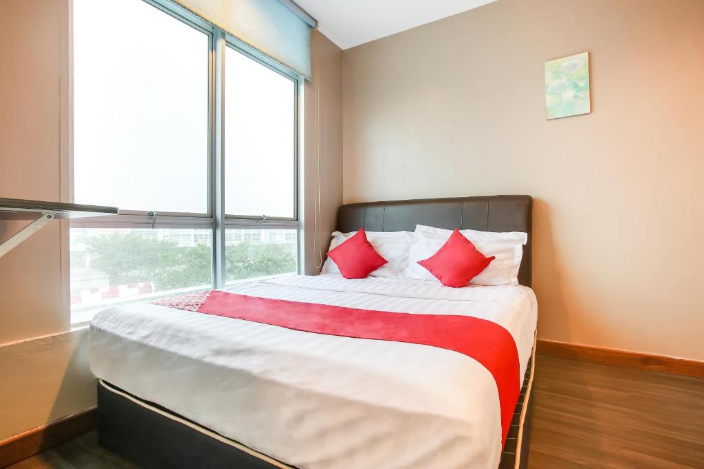 a bedroom with a bed with red pillows and a window at OYO 90282 Hotel Taj Inn, Seksyen 7 in Shah Alam