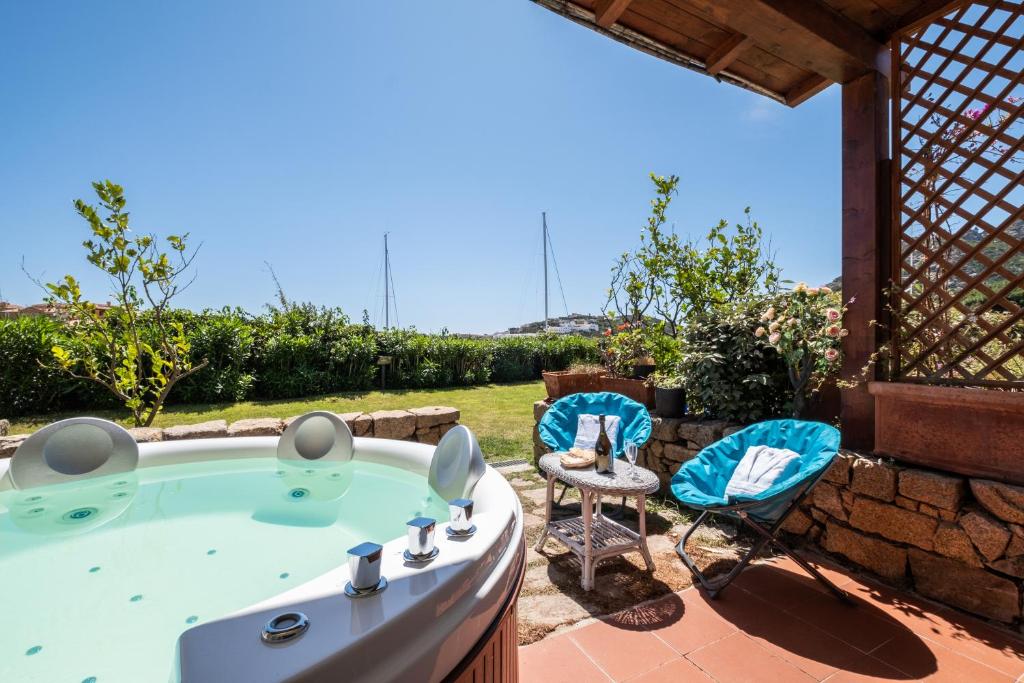 einen Whirlpool im Garten mit 2 Stühlen und einem Tisch in der Unterkunft [PORTO CERVO] VILLETTA CON JACUZZI PRIVATA in Porto Cervo