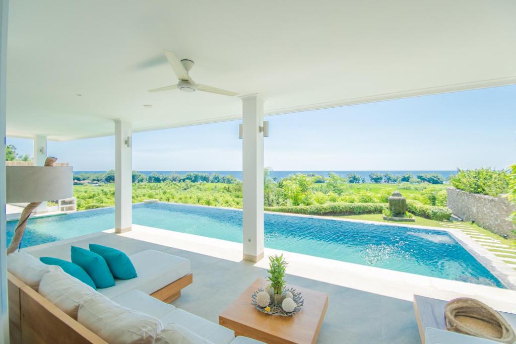 - un salon avec un canapé et une piscine dans l'établissement Deep Blue Villa Bali, à Umeanyar