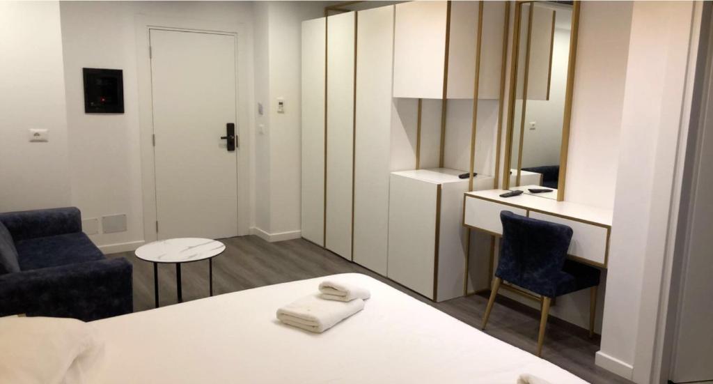 a room with a bed and two chairs and a kitchen at HOTEL BAR RESTORANT YLLI in Shëngjin