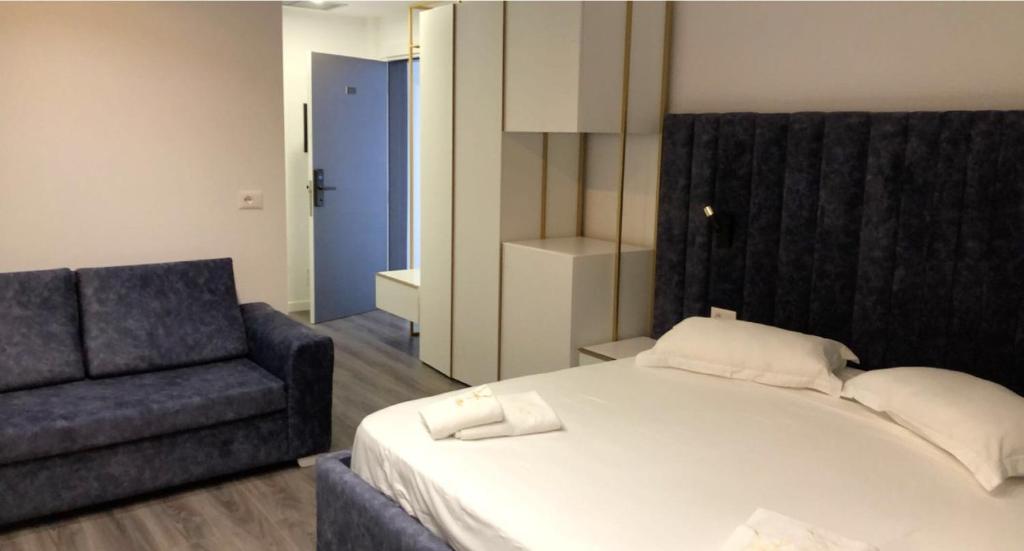 a bedroom with a bed and a couch at HOTEL BAR RESTORANT YLLI in Shëngjin