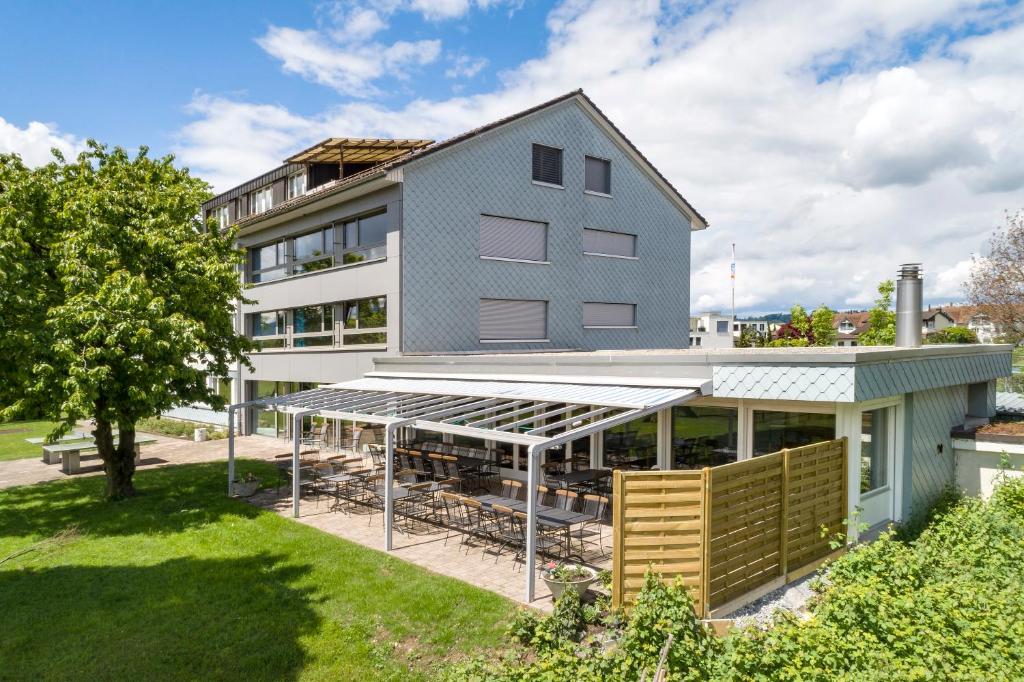 ein Apartmenthaus mit einem Solarium davor in der Unterkunft Rapperswil-Jona Youth Hostel in Rapperswil-Jona