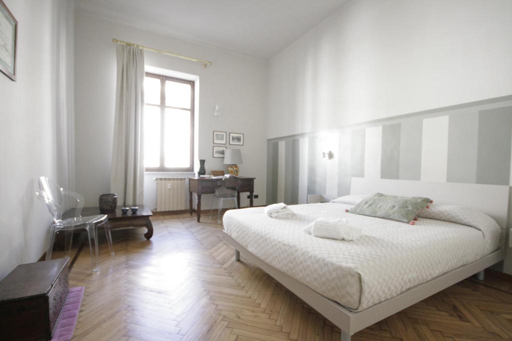 トリノにあるLa Grande Bellezzaの白いベッドルーム(大型ベッド1台、デスク付)