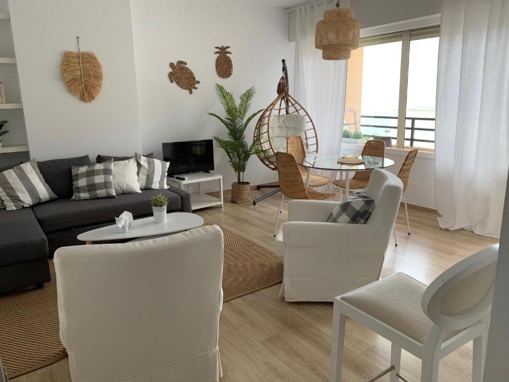 PERLA DEL SOL في توريمولينوس: غرفة معيشة مع أريكة وطاولة