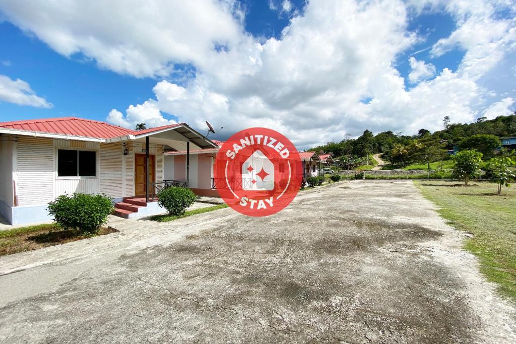 a house with a red sign in front of it at OYO 90284 Kampung Stay Kilimu in Ranau