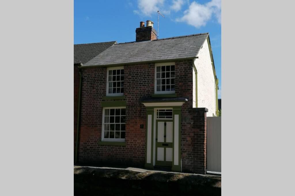 una casa de ladrillo rojo con puerta blanca en No 1 Church Street en Whitchurch