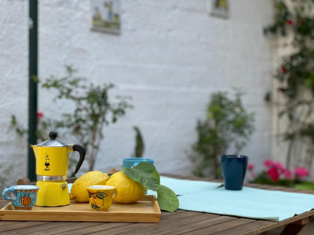 een houten tafel met citroenen en een waterkoker erop bij Casa Di Nicola in Cetara