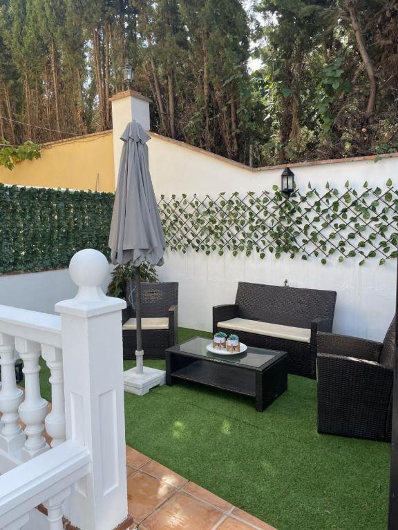 a patio with a white fence and green grass at casa espiga in Benalmádena