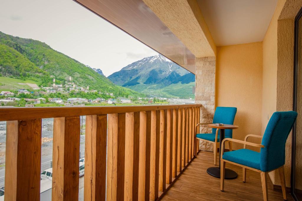a balcony with two chairs and a view of a mountain at Gistola Hotel Mestia in Mestia