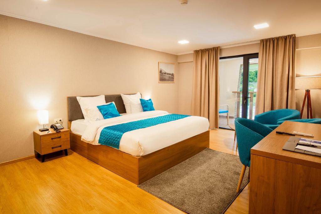 a hotel room with a bed and a desk at Gistola Hotel Mestia in Mestia
