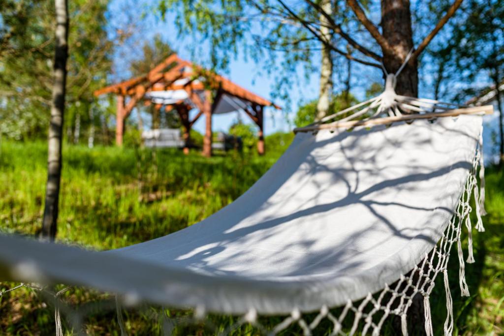 een hangmat in een park met een prieel bij Dom w dolince in Iwaniska