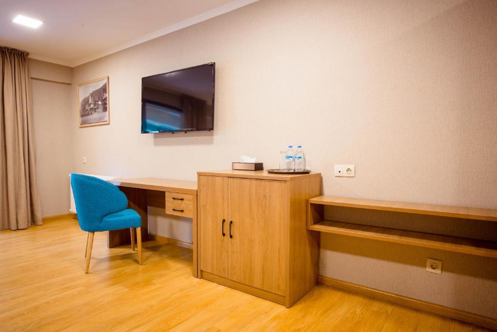 a hospital room with a desk and a blue chair at Gistola Hotel Mestia in Mestia