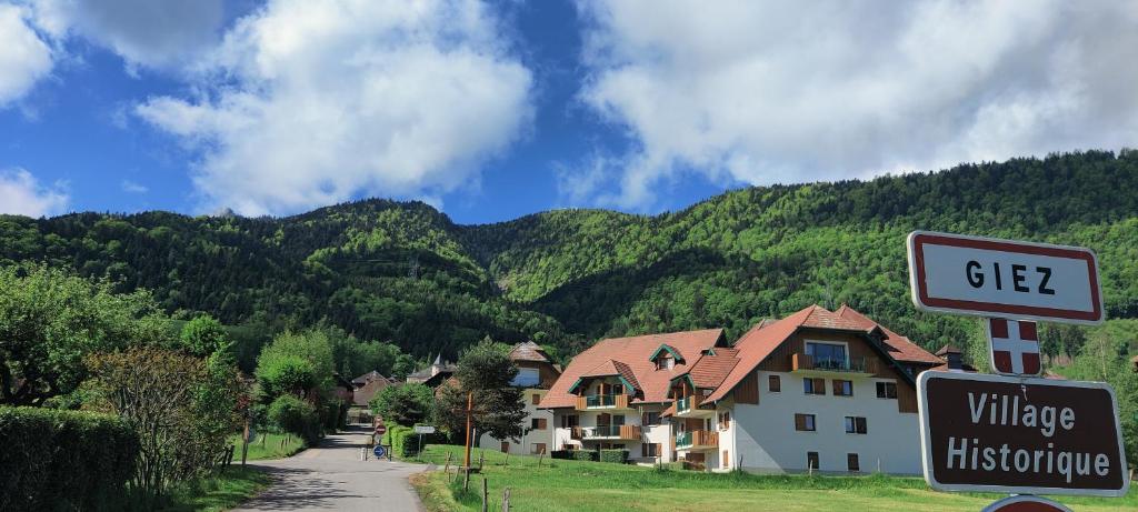 a street sign in front of a village with a house at C le birdie in Giez