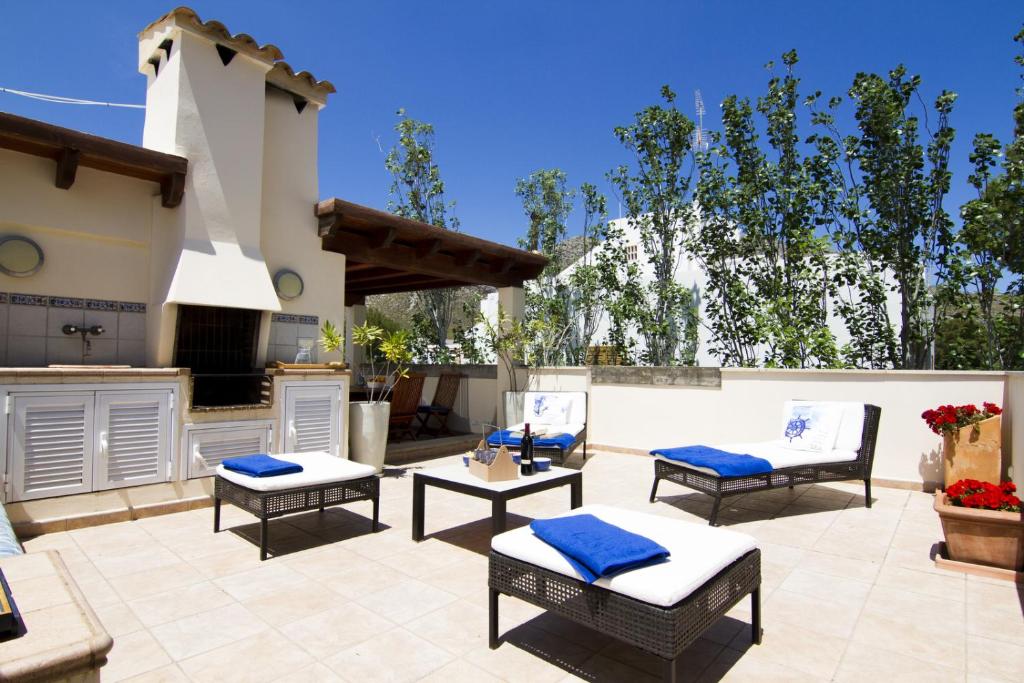 a patio with four chairs and a grill and a kitchen at Can Piscis in Pollença
