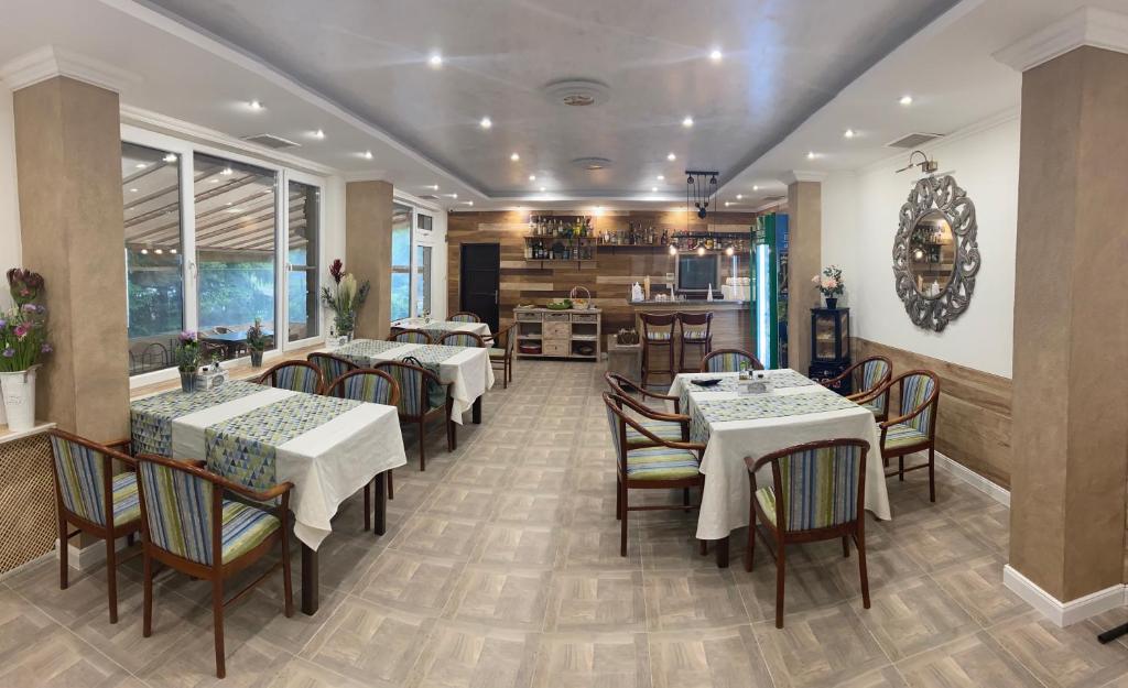 a restaurant with tables and chairs and a kitchen at Apart Hotel Central Razgrad in Razgrad