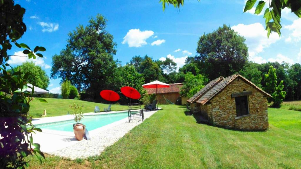 une maison avec piscine et un bâtiment avec frisbees rouges dans l'établissement Gites Le Pagus, à Simeyrols