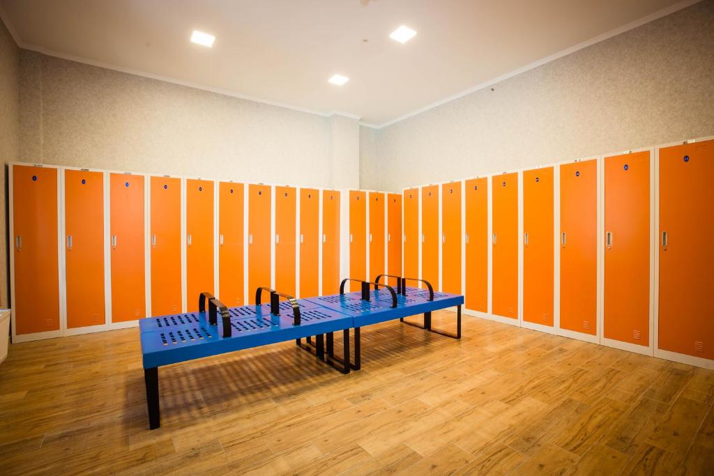 a locker room with orange lockers and a blue bench at Gistola Hotel Mestia in Mestia