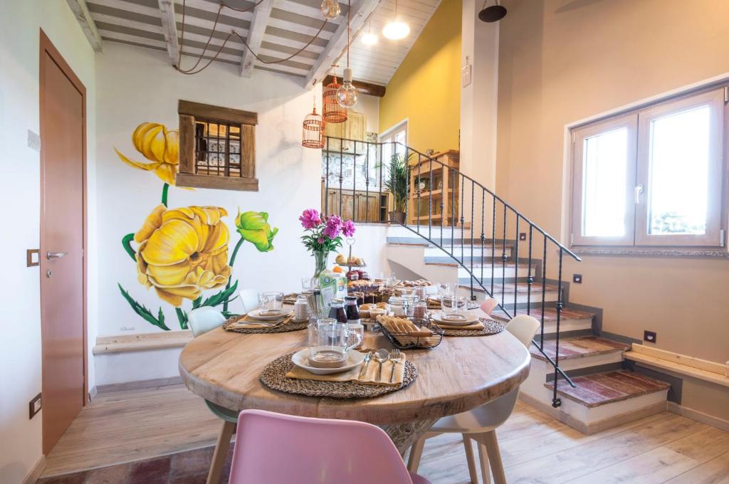 comedor con mesa, sillas y escaleras en B&B Botton d'Oro Valle Imagna en Fuipiano Valle Imagna