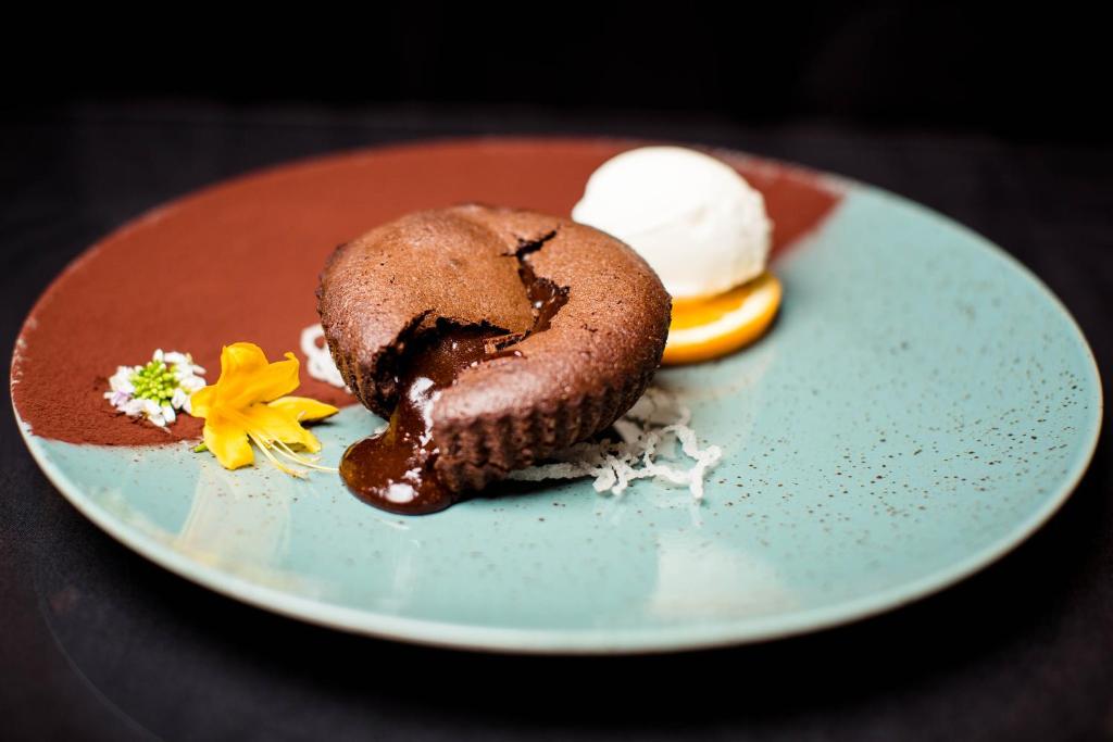 a chocolate muffin on a blue plate with ice cream at Gistola Hotel Mestia in Mestia