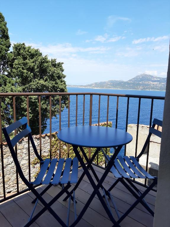 une table et des chaises sur un balcon avec l'océan dans l'établissement Casa Santa, à Calvi