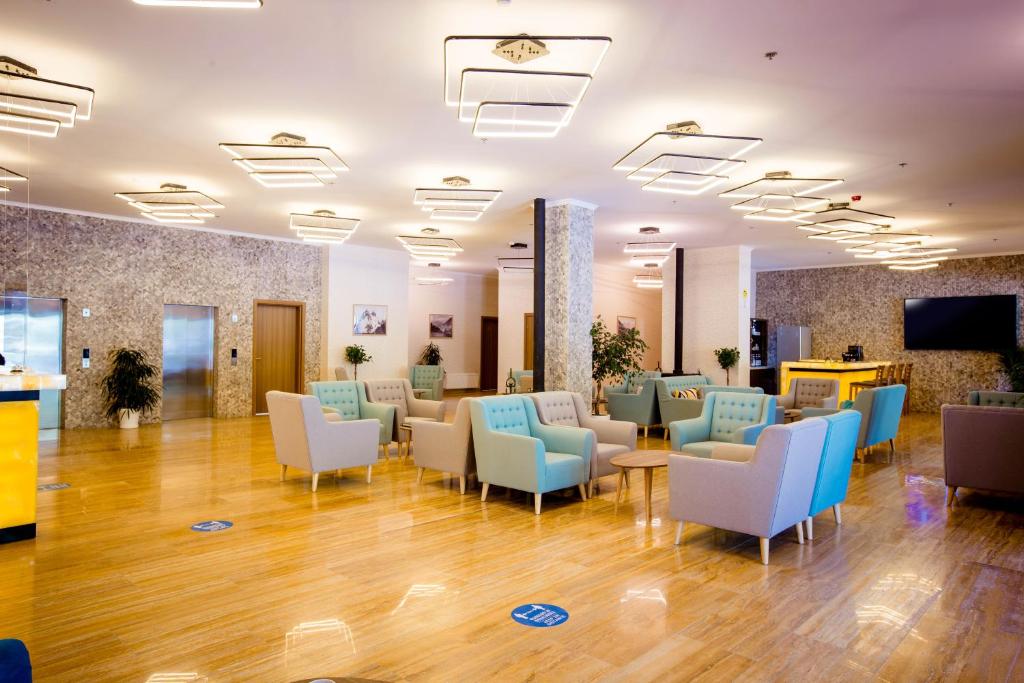 a lobby with a waiting room with blue and white chairs at Gistola Hotel Mestia in Mestia