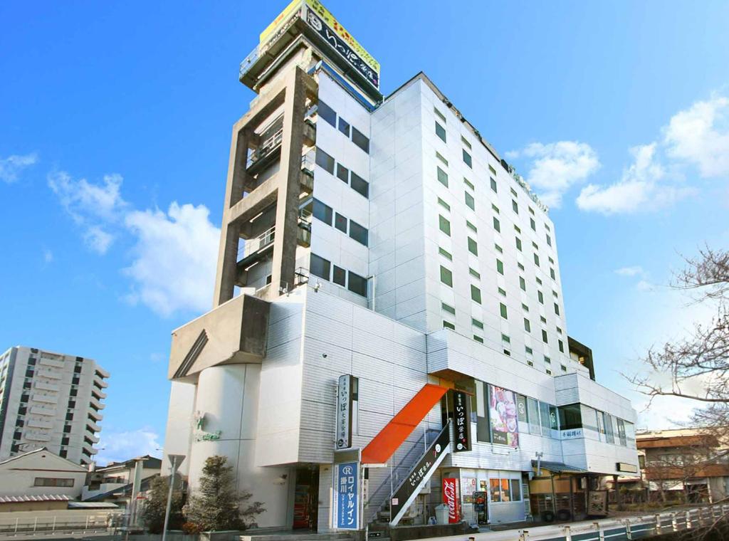 un edificio blanco alto con un reloj en él en Royal Inn Kakegawa (Station Hotel 2) en Kakegawa