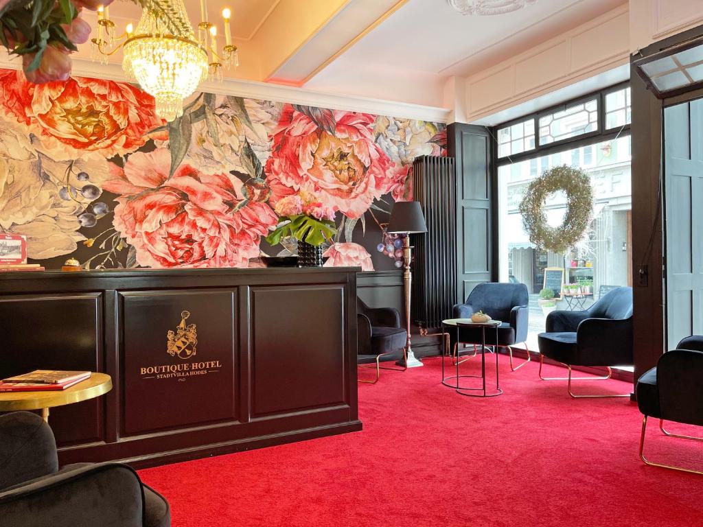 Boutique-Hotel Stadtvilla Hodes في فولدا: غرفة معيشة مع جدارية زهرة على الحائط