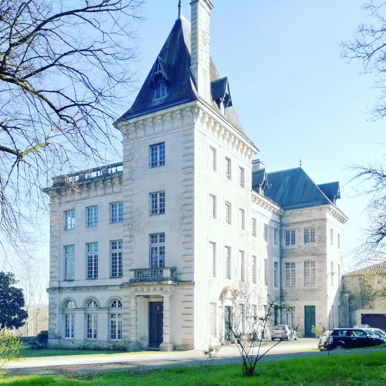 un grand bâtiment blanc avec une tour en haut dans l'établissement Château de Chasseneuil sur Bonnieure, à Chasseneuil-sur-Bonnieure