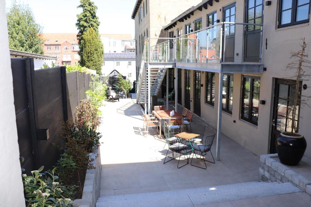 een patio met tafels en stoelen in een gebouw bij Hotel Petite B&B in Haderslev